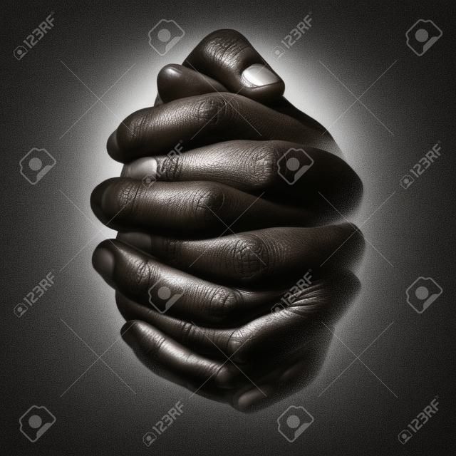 Lage sleutel, sluiten van handen van een trouwe volwassen man bidden, handen gevouwen, met elkaar verbonden vingers in aanbidding aan God. Geïsoleerde zwarte achtergrond. Concept voor religie, geloof, gebed en spiritualiteit.