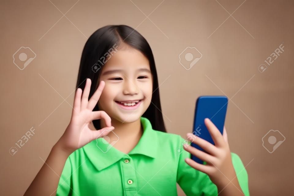 Smiling deaf girl talking using sign language on the smartphone's cam