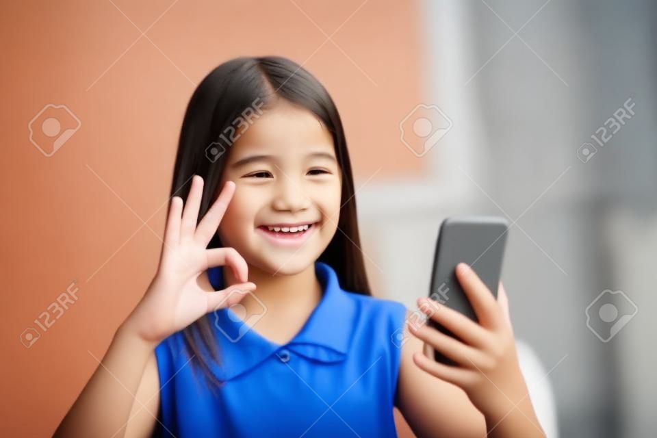 Smiling deaf girl talking using sign language on the smartphone's cam