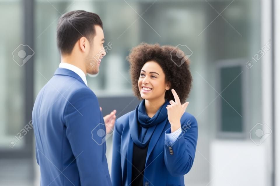 Twee zakenmensen in een informeel gesprek voor een bedrijfsgebouw