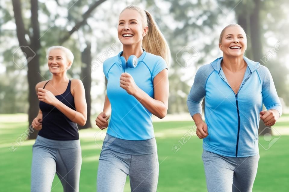 老人和妇女和年轻女性教练员锻炼在新鲜空气。户外活动，健康的生活方式，强壮的身体，健康的身材。时尚，现代的运动服。不同的世代
