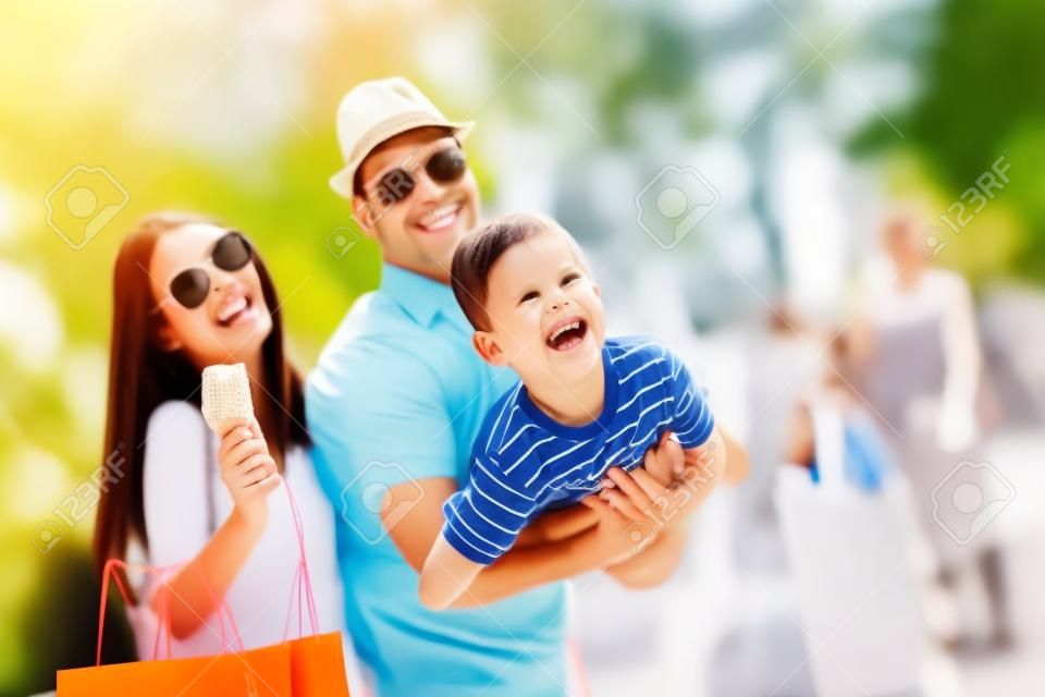 Szczęśliwa rodzina bawi się na świeżym powietrzu po zakupach