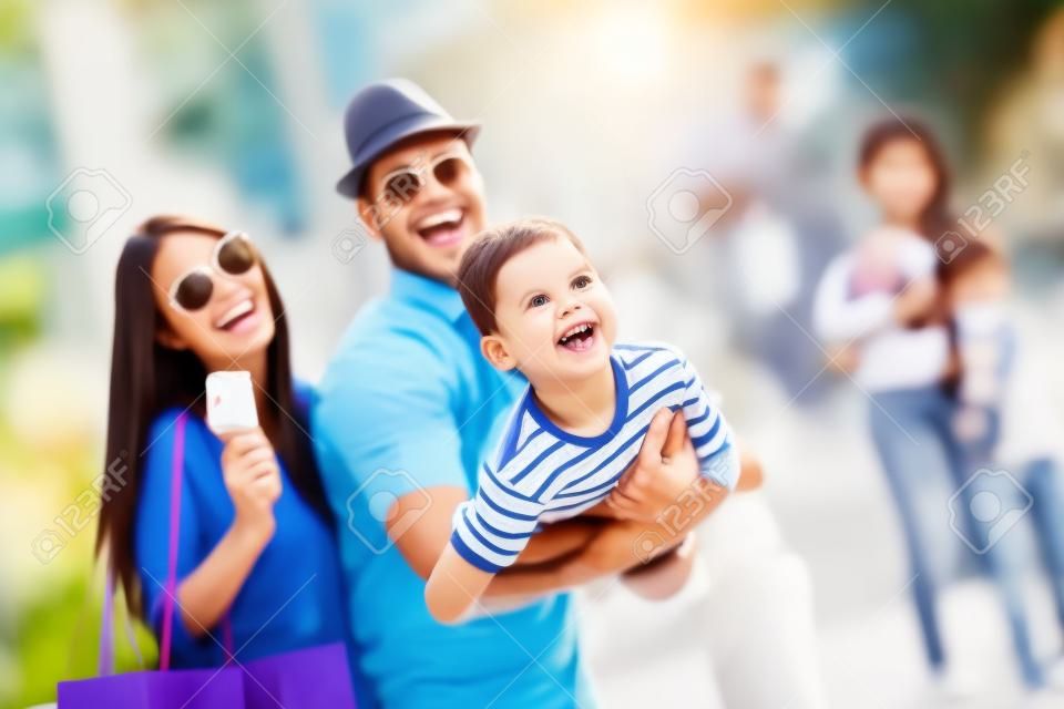 Szczęśliwa rodzina bawi się na świeżym powietrzu po zakupach