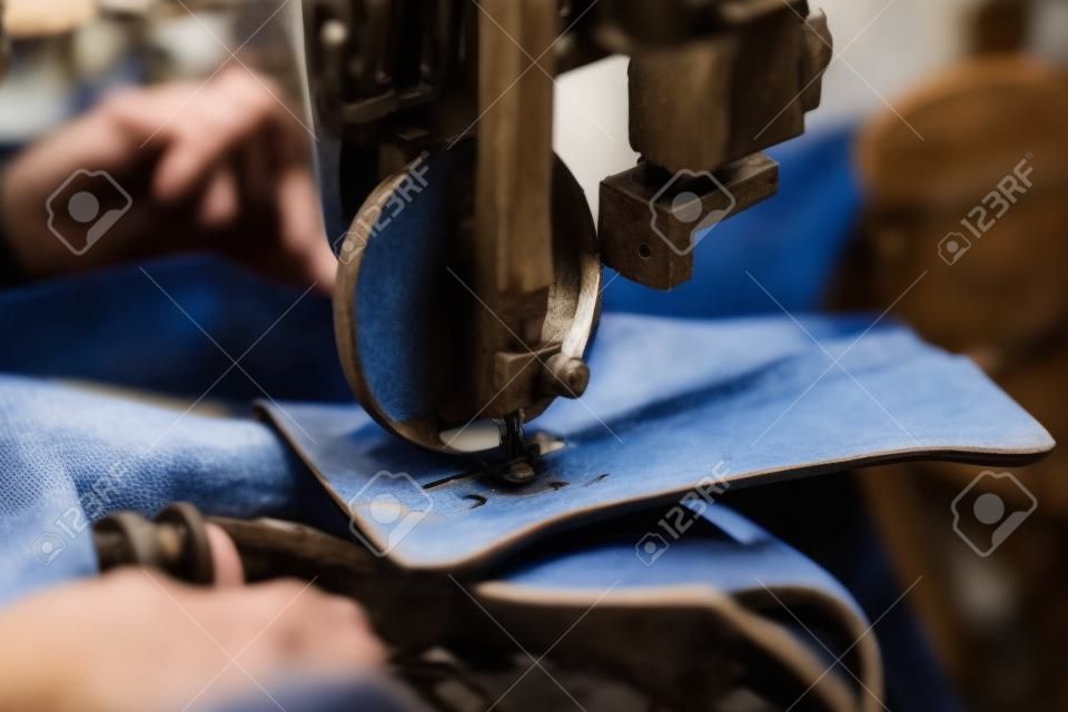 Kobiece ręce szewca zszywające część buta w ręcznie robionym przemyśle obuwniczym