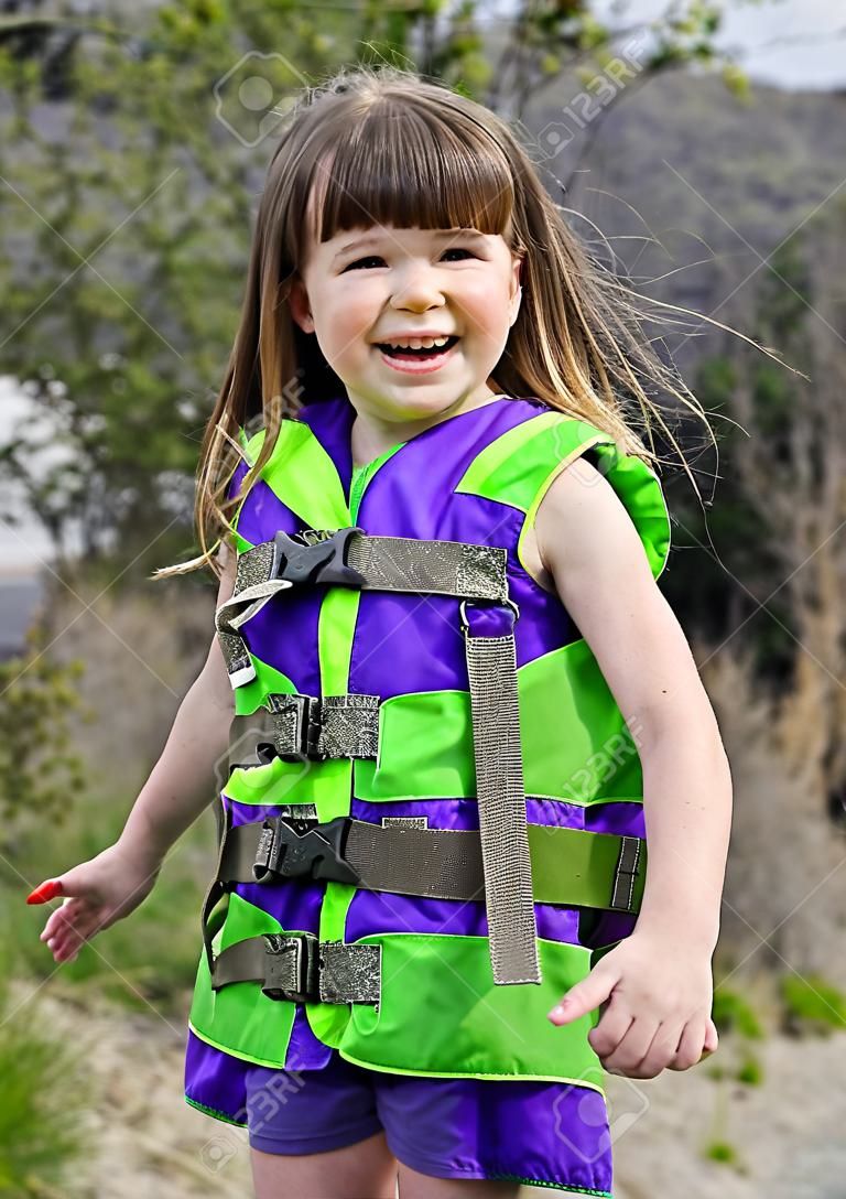 This cute 3 year old Caucasian girl is smiling and happy while playing outdoors. 