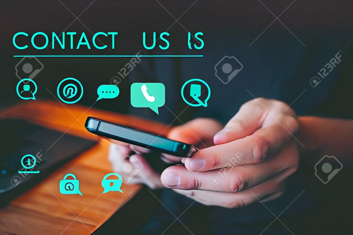 Contact us support hotline, people connect. User man use a smartphone with virtual screen member contact icons ( phone, live chat, email, address ). Customer service, helpdesk advice online support.