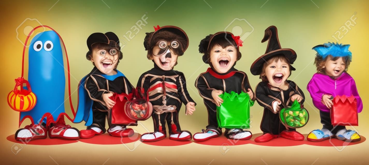 enfants dans différents costumes avec des sacs de bonbons