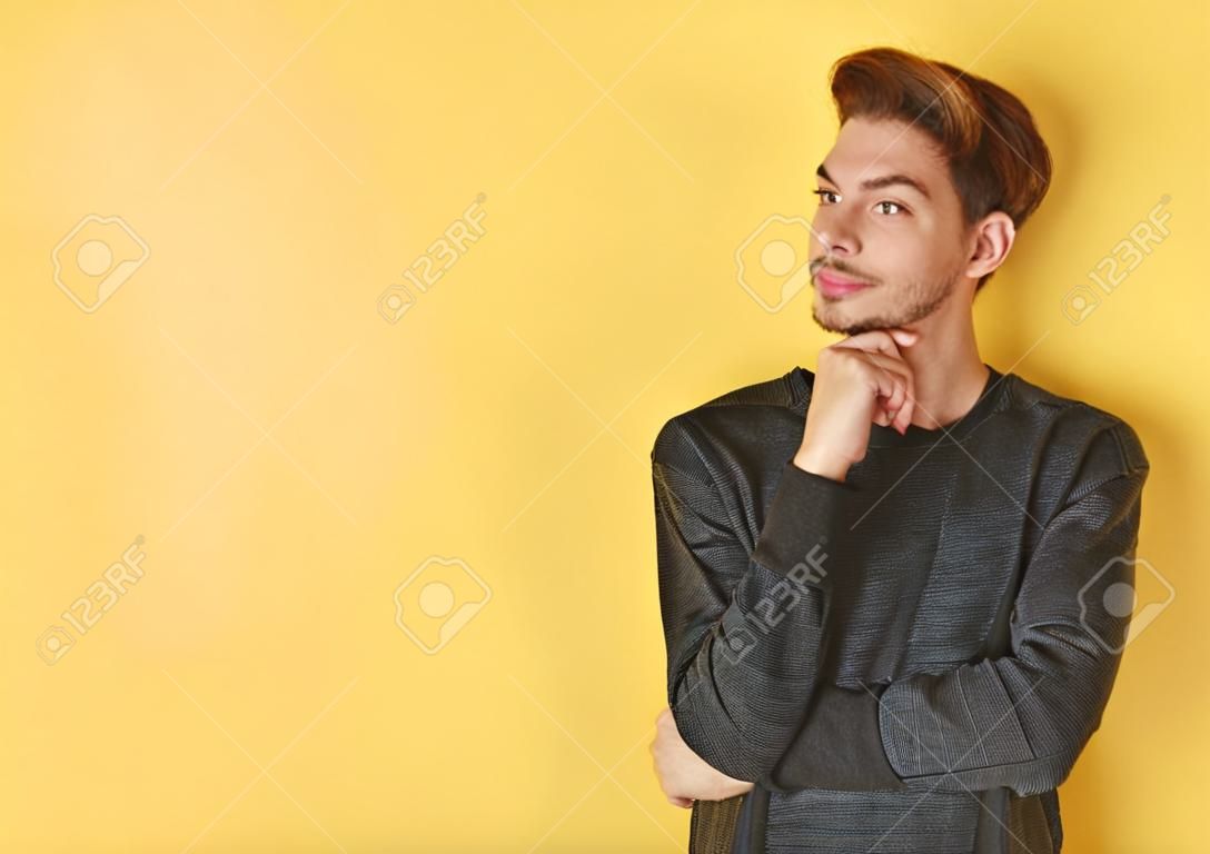 Portrait of a smart  young man standing against yellow backgroun
