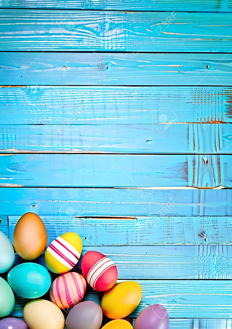 Színes húsvéti tojás elrendezve a kék háttér.