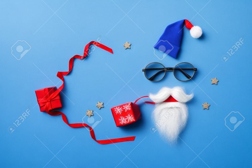 Regalo di Natale o regalo per Babbo Natale segreto con cappello da Babbo Natale, occhiali e barba su sfondo blu.