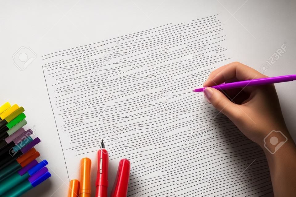 Kleurenpen en blanco papier met handschrift op lege pagina
