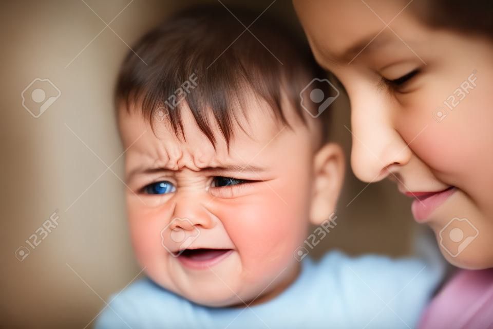 madre un bambino piange sullo sfondo della finestra