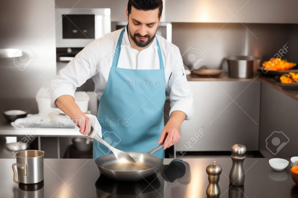 Küchenchef bereitet Gerichte in einer Pfanne erhitzen. Kochen. stock Bild