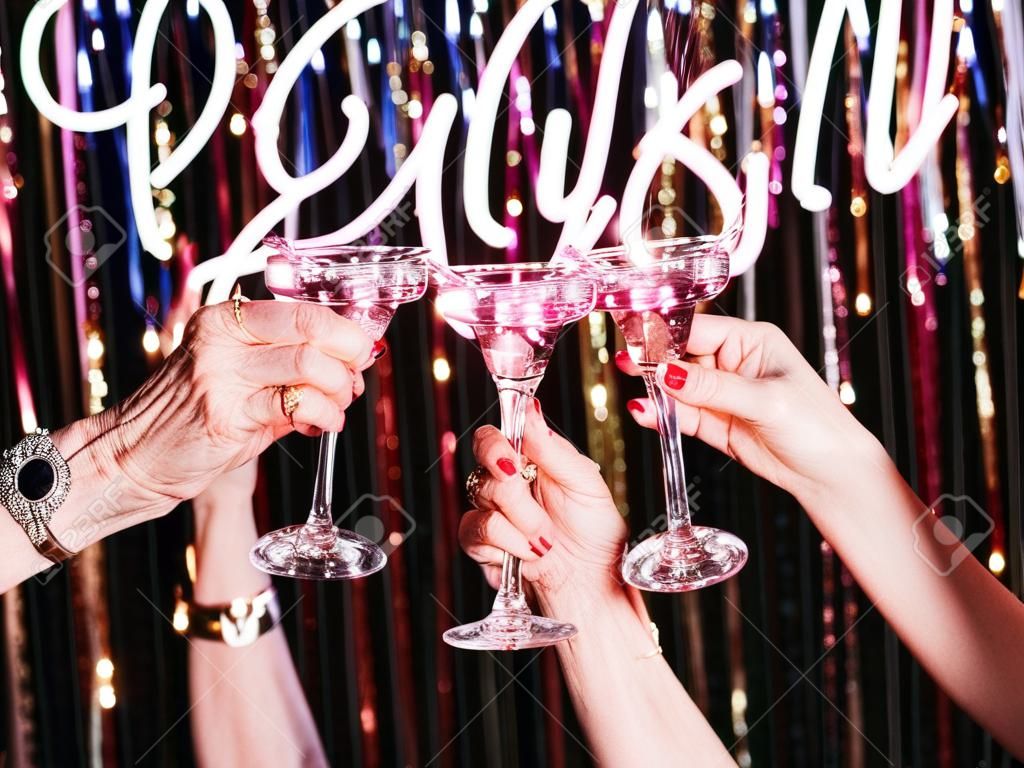 Dos manos de mujeres maduras bebiendo vino espumoso en la fiesta. vacaciones, evento de vida, celebración