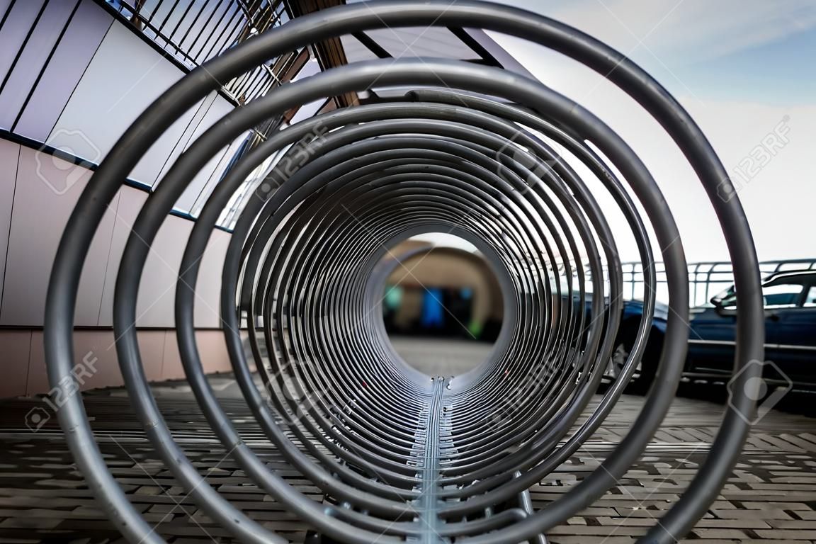 a bicycle stand and a wheelchair space that looks futuristic and interesting. geometric vision and perceptual composition. lines and a tunnel of steel and iron spirals.