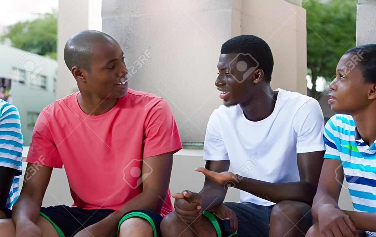 Grupo de inmigrantes afroamericanos hablando al aire libre en el verano en la ciudad