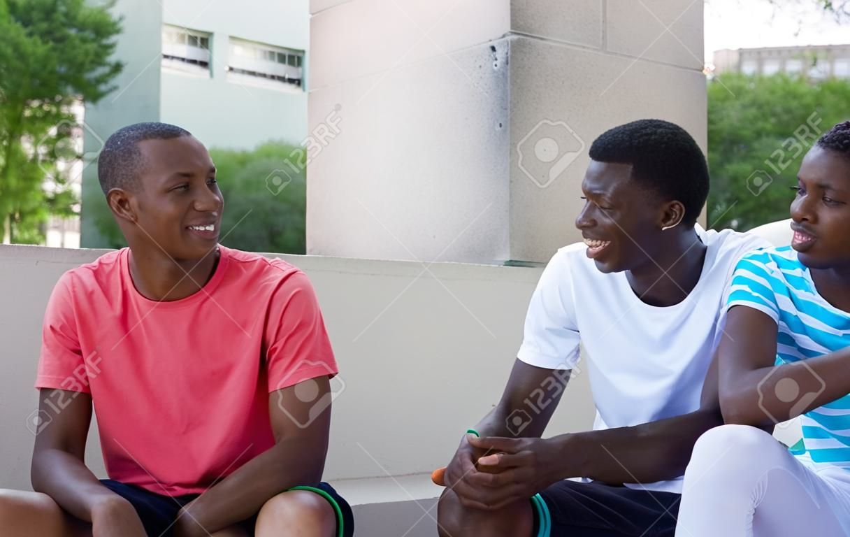 Grupo de inmigrantes afroamericanos hablando al aire libre en el verano en la ciudad