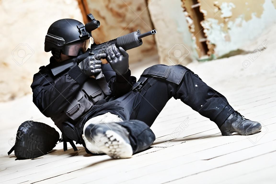 Indústria militar. Forças especiais ou soldado da polícia antiterrorista, contratante militar privado armado com pistola pronta para atacar deitado no chão durante a operação de limpeza, missão