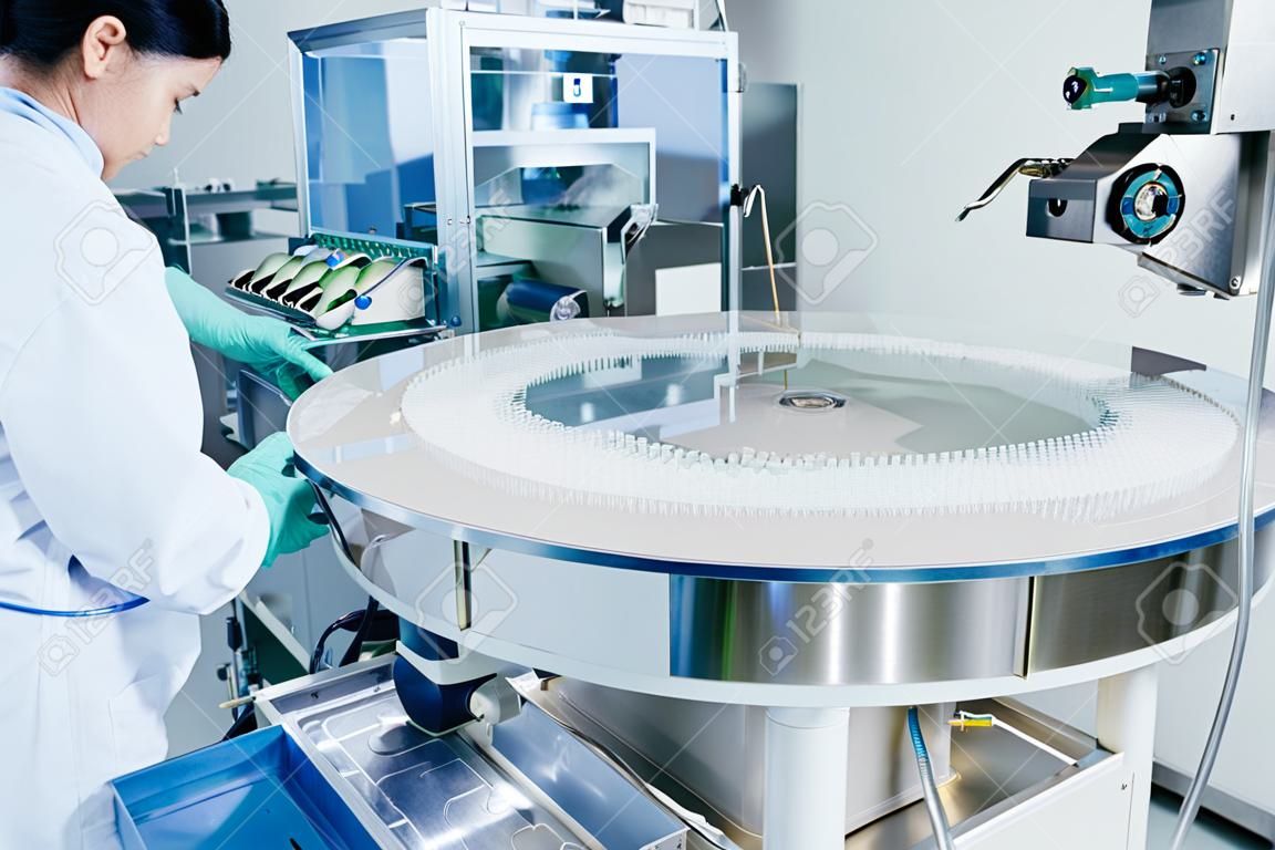 Pharmaceutics. Pharmaceutical industry worker operates tablet blister and cartoning packaging machine at factory