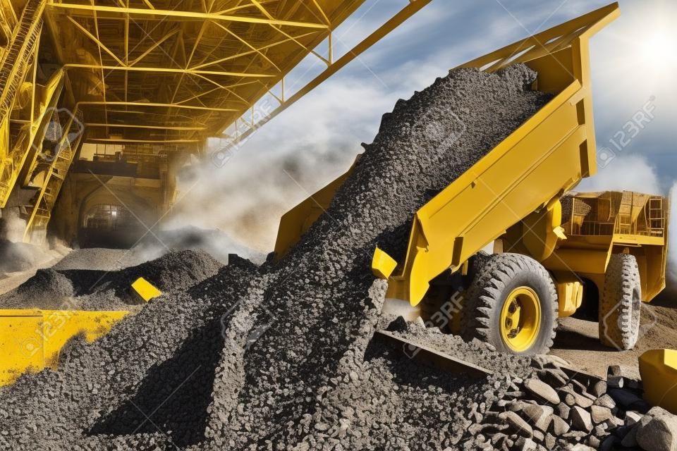 Mining industry. heavy wheel dump truck unloading granite rock or ore into crushing and sorting plant