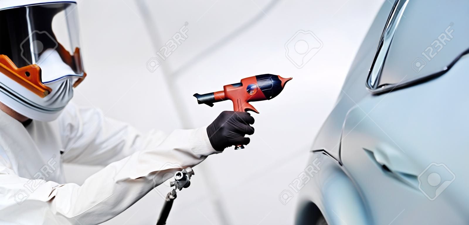 automobile painting. car painter with gun in chamber