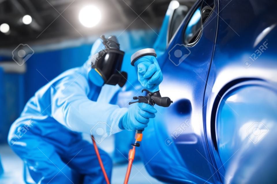 auto painting worker. car in a paint chamber during repair work