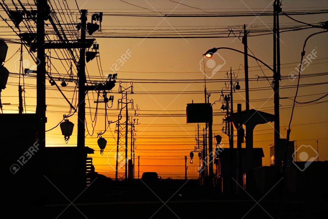 Silhouette electric pole and cable over the dramatic sunset, Japan.