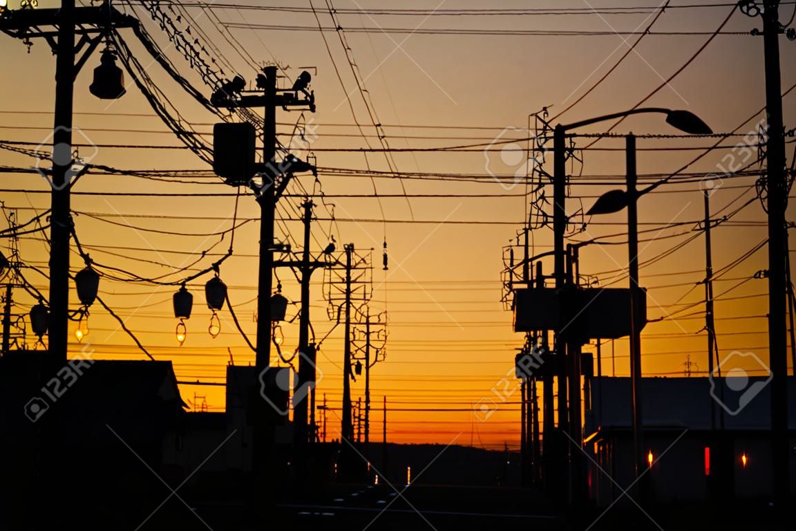 Silhouette electric pole and cable over the dramatic sunset, Japan.