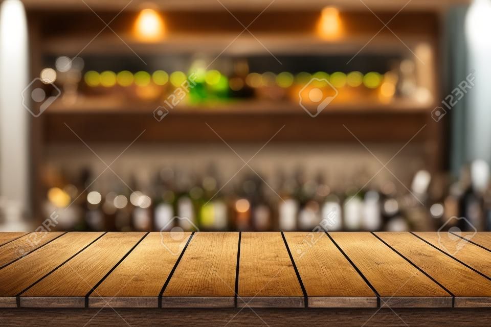 Tavolo di legno in vista di sfondo offuscata di bevande bar
