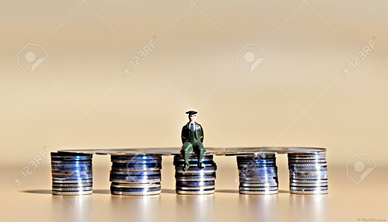 Een miniatuurman die op twee stapels munten zit.