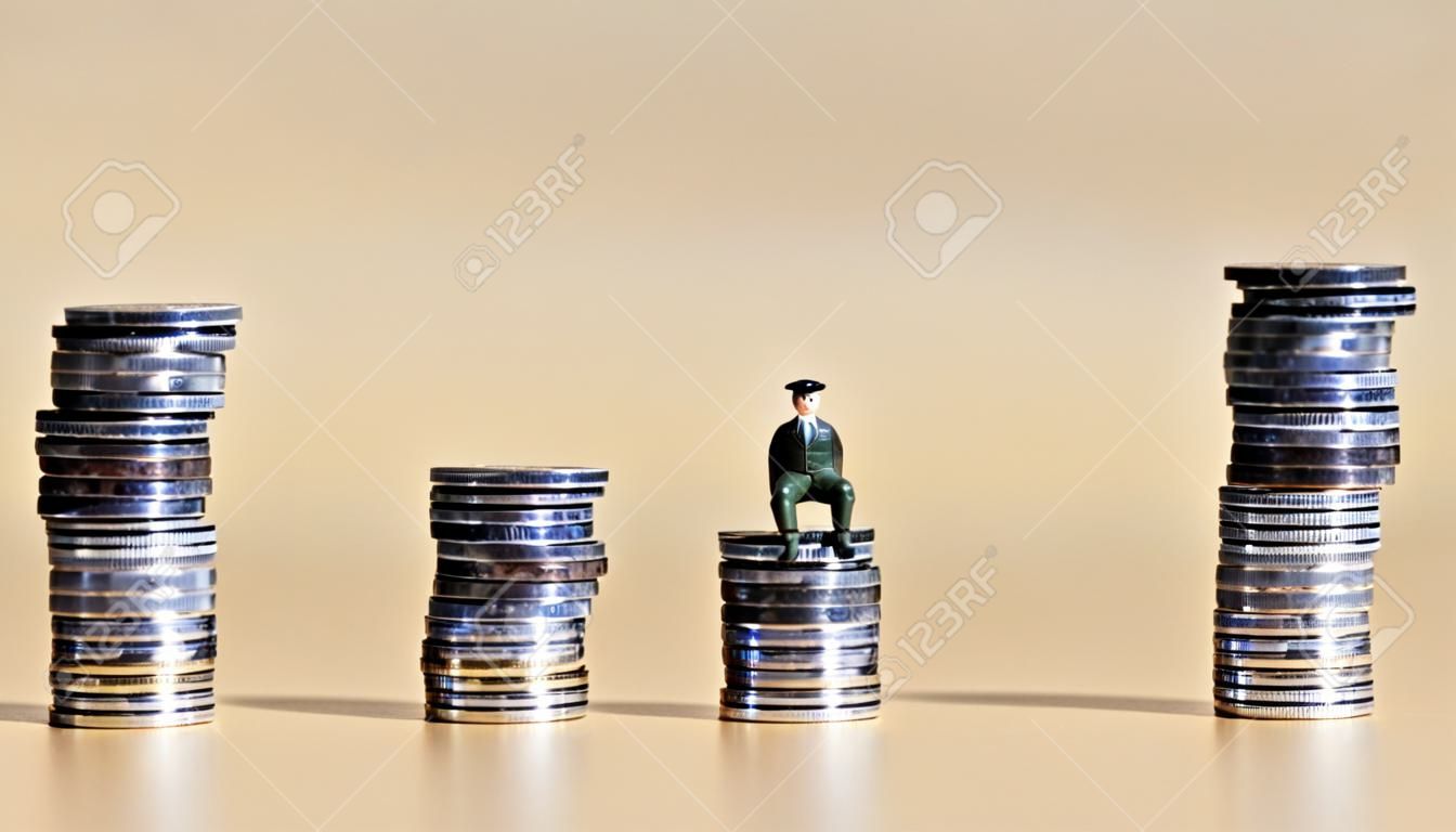 Een miniatuurman die op twee stapels munten zit.