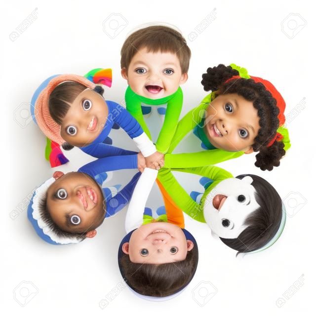 Grupo de niños juntando las manos sobre fondo blanco.