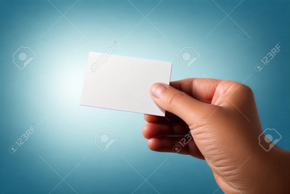 Hand holding visitekaartje op muur achtergrond