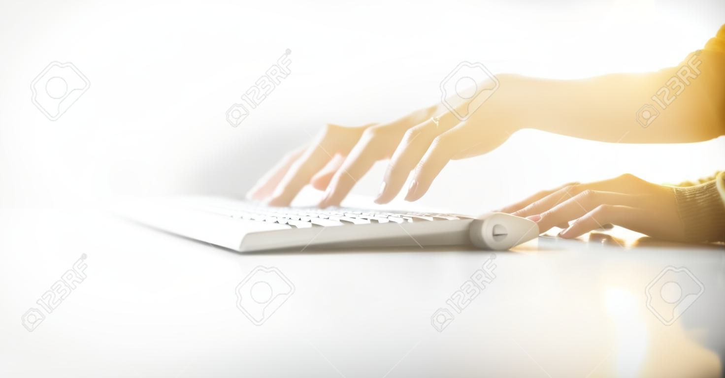Foto de closeup de mãos femininas digitando texto em um teclado. Efeitos visuais, fundo branco.