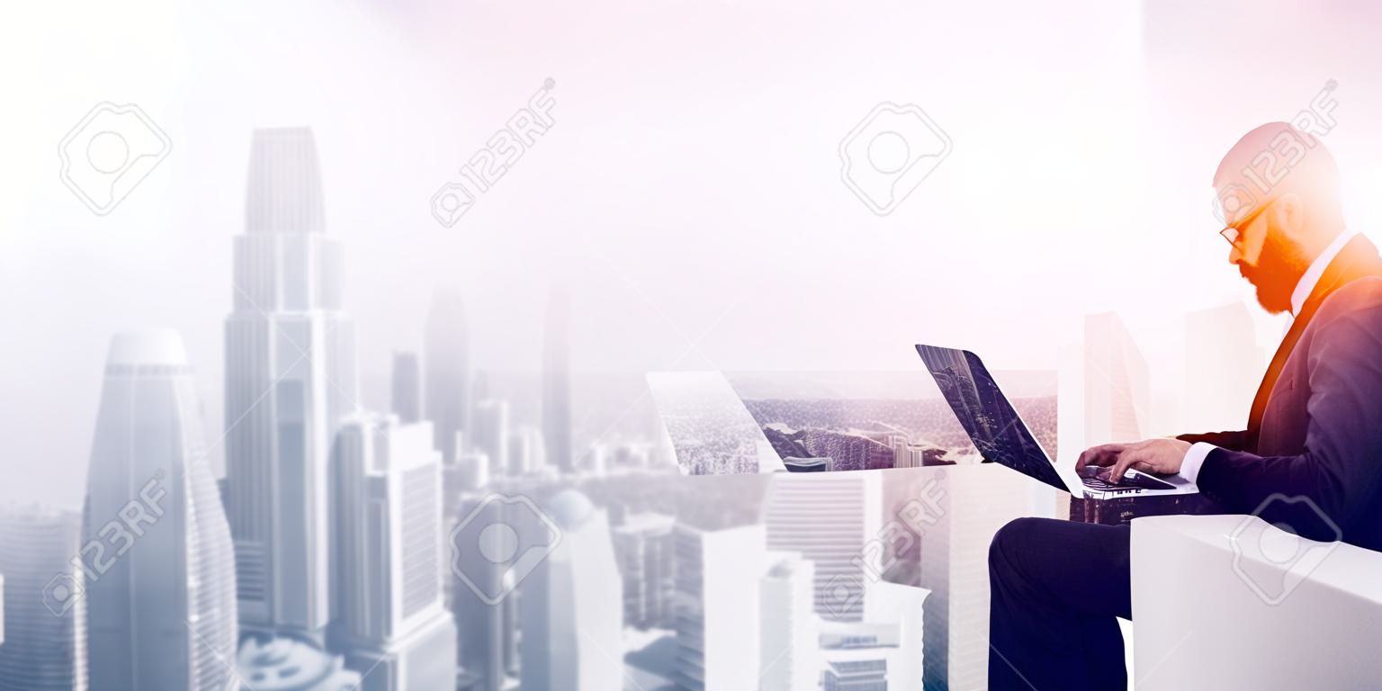 Double exposure photo bearded businessman wearing black shirt and glasses.Banker using contemporary notebook hands,work online banking.Panoramic view modern skyscraper city background