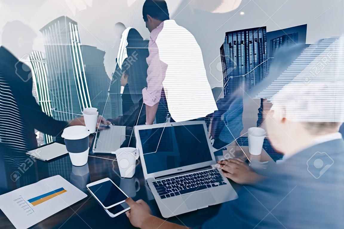 Double exposure of young coworkers working together on new startup project in modern office.Business meeting concept.Skyscraper building at the blurred background.Horizontal,flare effect