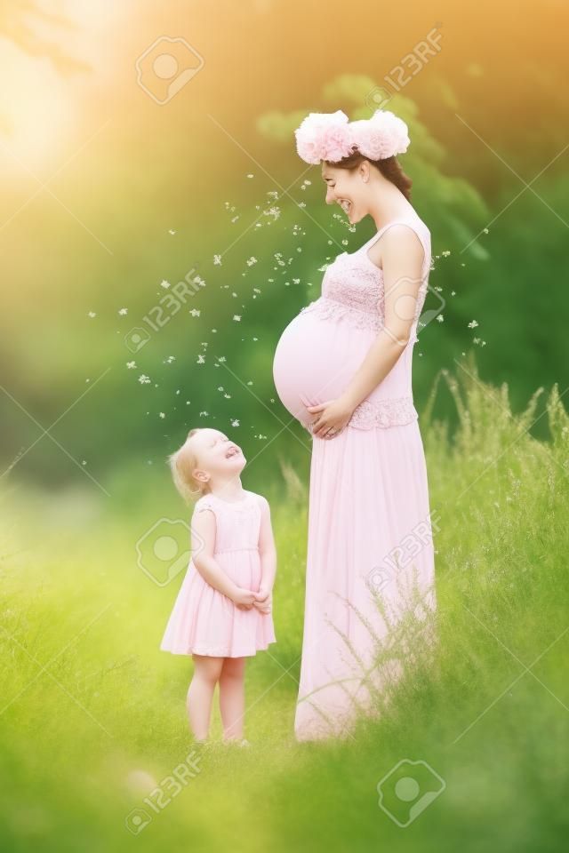 Schwangere Mutter und Tochter haben Spaß im Freien