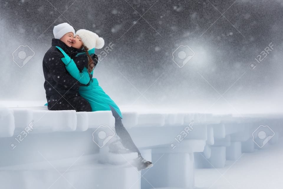 Junger Kerl und Mädchen im Winter tragen, umarmen und die Landschaft des Winters genießen.