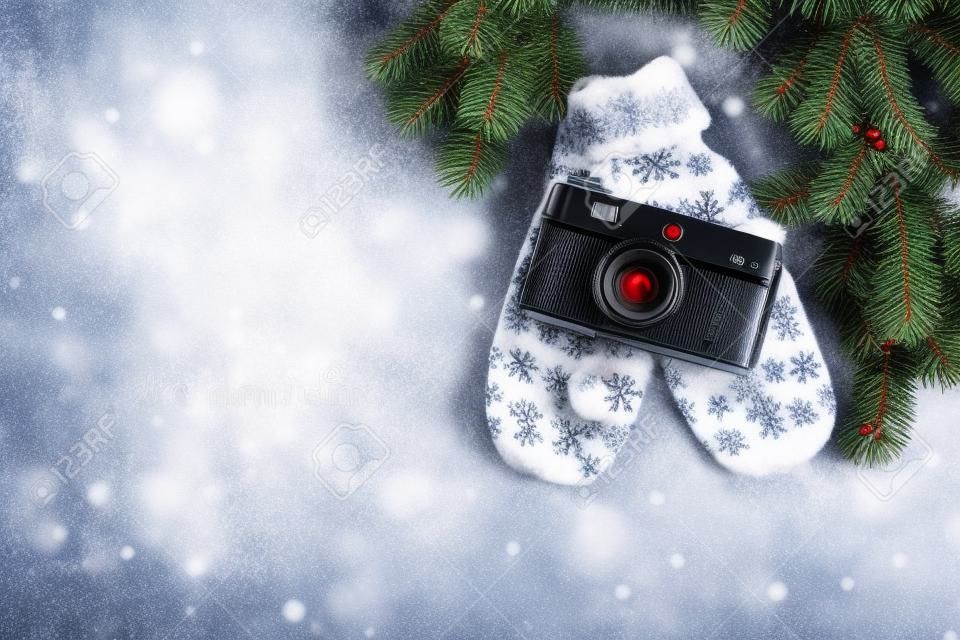 Biglietto di auguri di Natale. Sfondo di Natale con abete di neve, macchina fotografica e guanti. Vista dall'alto con spazio per i tuoi saluti o foto