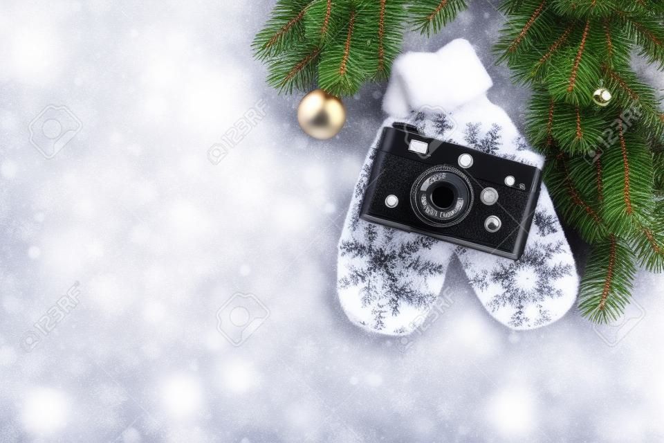 Boże Narodzenie kartkę z życzeniami. Bożenarodzeniowy tło z śnieżną jodłą, aparatem i rękawiczkami. Widok z góry z miejscem na pozdrowienia lub zdjęcie
