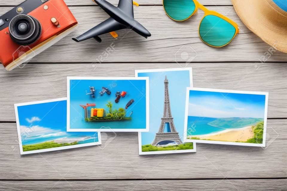 Travel concept with vacation photos, airplane toy, camera and sunglasses on wooden table. Top view flat lay with copy space