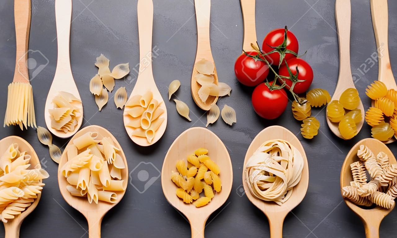 Various pasta in spoons. Top view flat lay