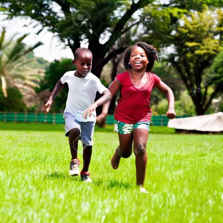 Portret działanie afrykańskich dzieci bawiących się i pracujących razem w parku.