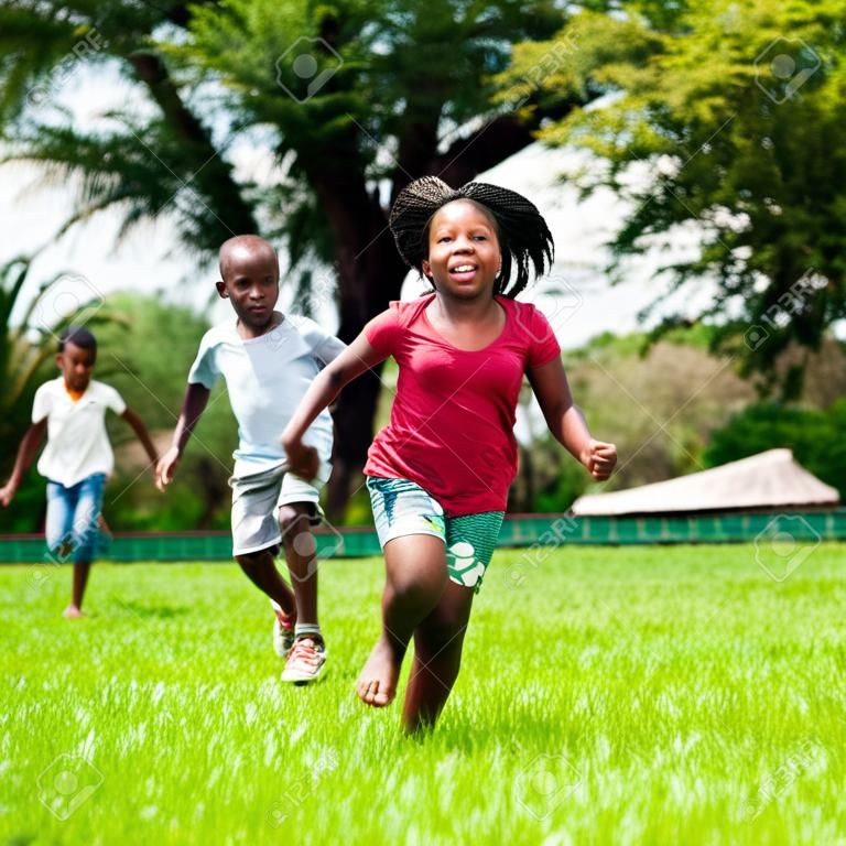 Portret działanie afrykańskich dzieci bawiących się i pracujących razem w parku.