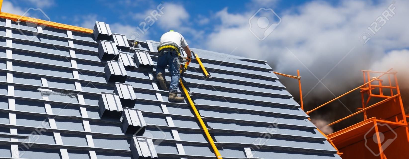 Dekarz pracujący na konstrukcji dachu budynku na budowie.