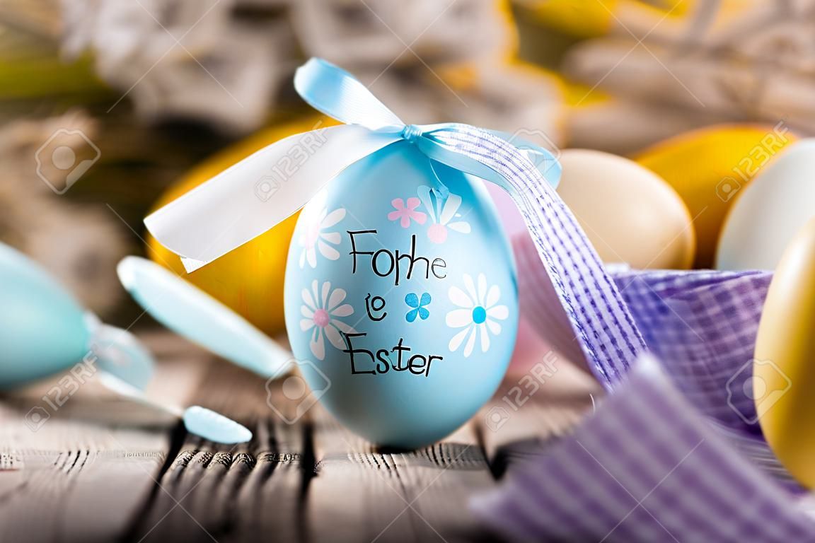Conejito lindo de los huevos de la decoración de Pascua. Felices Pascuas. Imagen en tonos de estilo vintage Texto en ALEMÁN HAPPY ESTER