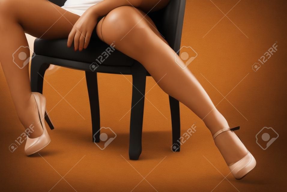 Frau sitzt im Stuhl mit Beine öffnen sich