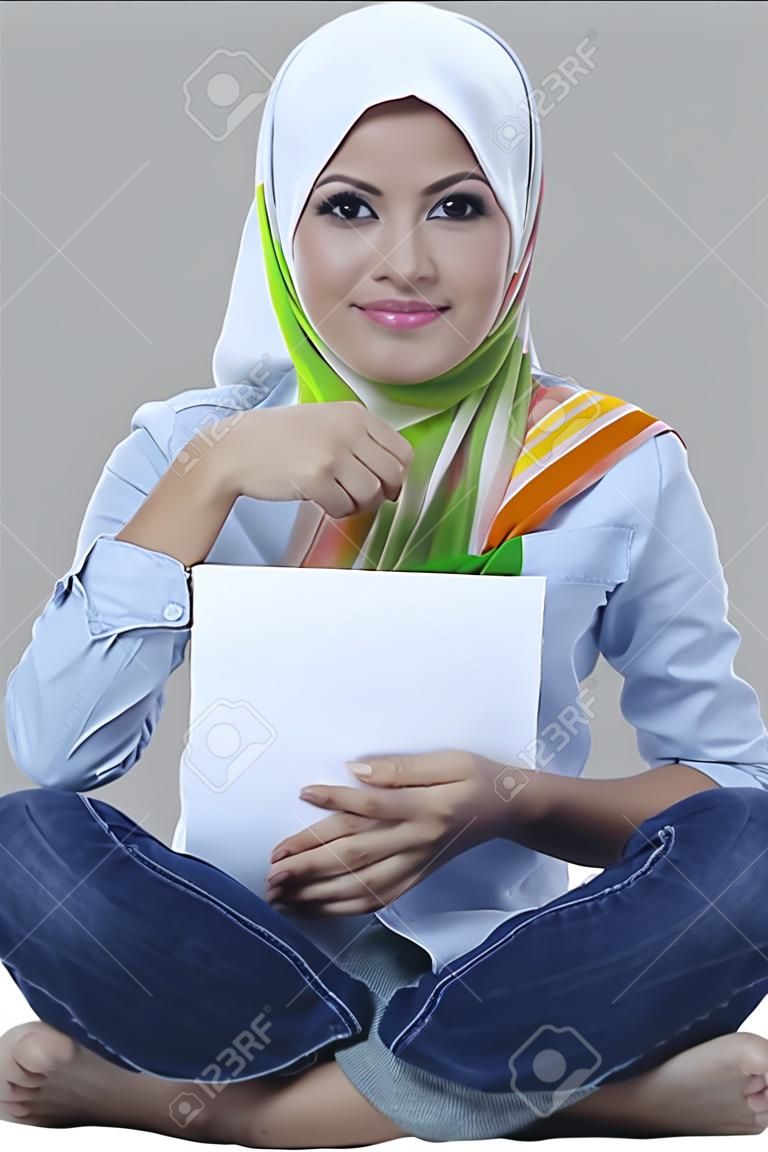 Красивые молодые мусульманские женщины сиденье и проведение пустой документ