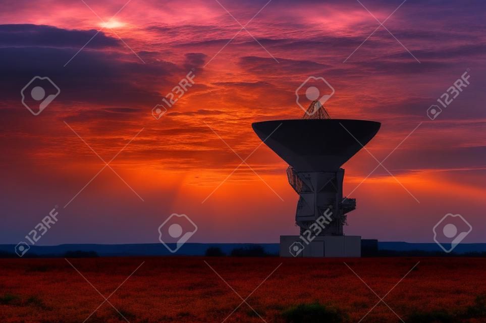 Antenna radar spaziale. Parabola satellitare al tramonto con cielo nuvoloso.