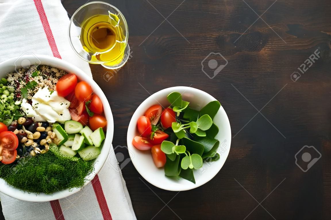 Vegetariano Vegan salada tigela ou buddha tigela com tomate, pepino, queijo mozzarella, quinoa, azeitonas e microgreens. Conceito de comida saudável e equilibrada no fundo escuro de madeira velha